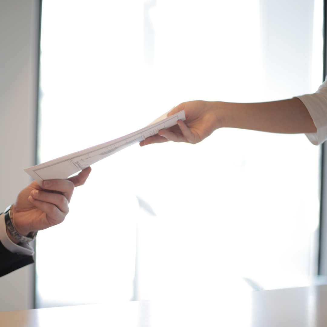 Image of a woman handing a man documents